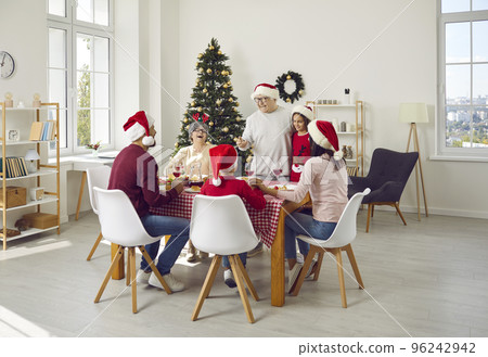 Happy family sitting around table, enjoying Christmas lunch and having fun together 96242942