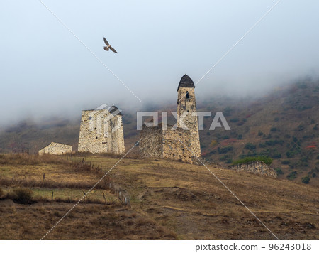 Battle towers Erzi in the Jeyrah gorge. Medieval tower complex Erzi, one of the largest medieval castle-type tower villages, located on the extremity of the mountain range in Ingushetia, Russia. Battle towers Erzi in the Jeyrah gorge. Medieval tower complex Erzi, one of the largest medieval castle-type tower villages, located on the extremity of the mountain range in Ingushetia, Russia. 96243018