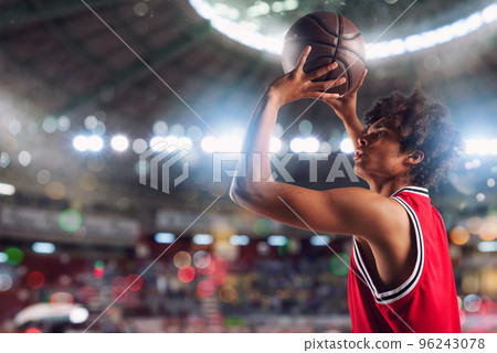 Basketball player throws the ball in the basket in the stadium full of spectators. Basketball player throws the ball in the basket in the stadium full of spectators. 96243078