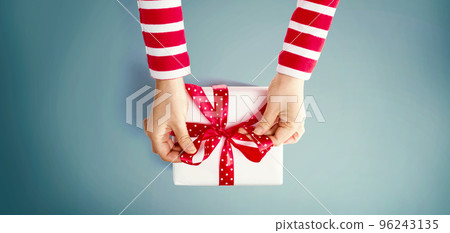 Person making a Christmas gift box 96243135