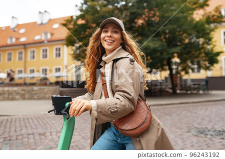 Close up portrait of young woman with electric scooter at the city Close up portrait of young woman with electric scooter at the city 96243192
