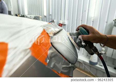 Close up of car cleaner polishing headlight with polish machine Close up of car cleaner polishing headlight with polish machine 96243305