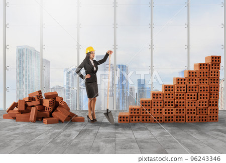 Businesswoman with helmet builds a growing stats bar with bricks 96243346