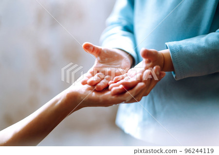 Mom helps her chaild wash her hands. They are rubbing their hands together creating foam with soap. Mom helps her chaild wash her hands. They are rubbing their hands together creating foam with soap. 96244119
