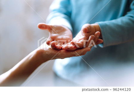Mom helps her chaild wash her hands. They are rubbing their hands together creating foam with soap. Mom helps her chaild wash her hands. They are rubbing their hands together creating foam with soap. 96244120