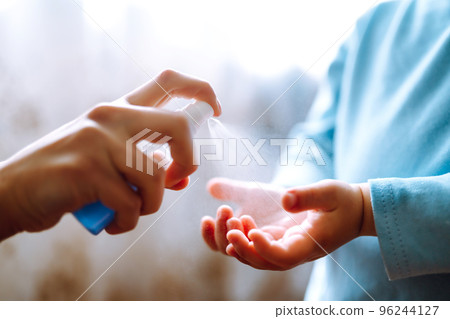 Hands with antiseptic. Mother and child using sanitize antiseptic for hand coronavirus protection. Hands with antiseptic. Mother and child using sanitize antiseptic for hand coronavirus protection. 96244127