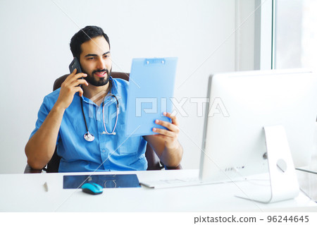 Happy doctor man talking phone at office Happy doctor man talking phone at office 96244645