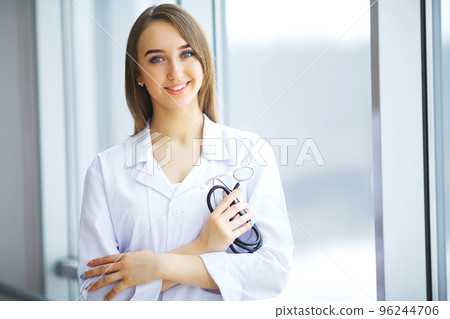 Cute brunette in medical gown and a stethoscope in an hospital 96244706