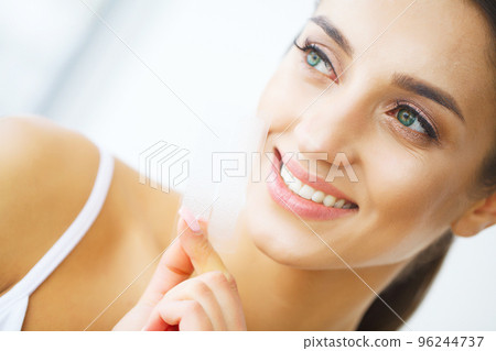 Teeth Whitening. Beautiful Smiling Woman Holding Whitening Strip. High Resolution Image Teeth Whitening. Beautiful Smiling Woman Holding Whitening Strip. High Resolution Image 96244737