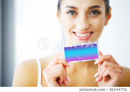 Teeth Whitening. Beautiful Smiling Woman Holding Whitening Strip. High Resolution Image Teeth Whitening. Beautiful Smiling Woman Holding Whitening Strip. High Resolution Image 96244738