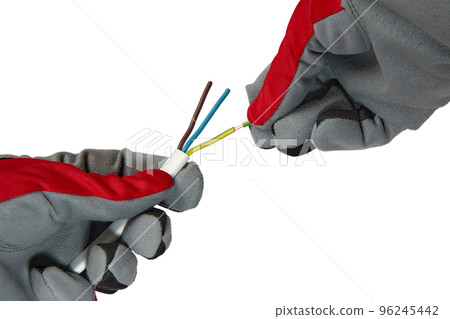 An electrician removes insulation from a three-core copper wire. Hands in protective gloves and electric cable isolated on white background 96245442