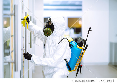 Cleaning and disinfection of office to prevent COVID-19, Man in protective hazmat suit washes office Cleaning and disinfection of office to prevent COVID-19, Man in protective hazmat suit washes office 96245641
