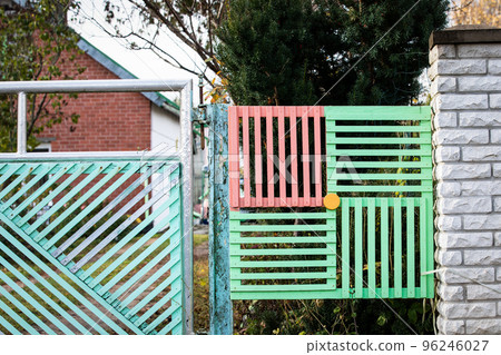 Colorful wooden plank fence. Architectural details and street view Colorful wooden plank fence. Architectural details and street view 96246027