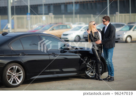 Happy young couple chooses and buying a new car for the family Happy young couple chooses and buying a new car for the family 96247019
