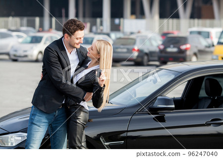 Happy young couple chooses and buying a new car for the family Happy young couple chooses and buying a new car for the family 96247040