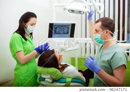 Young Dentist treating a female Patient in the dental studio Young Dentist treating a female Patient in the dental studio 96247171
