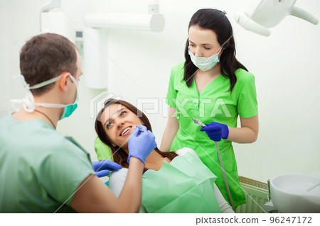Young Dentist treating a female Patient in the dental studio Young Dentist treating a female Patient in the dental studio 96247172