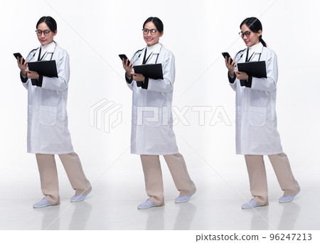 Full length 30s 40s Asian Woman Doctor with stethoscope, walking forward left right, wear formal Coat pant shoes. Smile Hospital female carry Patient Chart phone over white background isolated 96247213