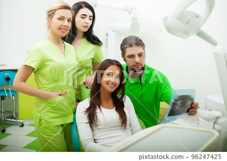 Young Dentist treating a female Patient in the dental studio Young Dentist treating a female Patient in the dental studio 96247425