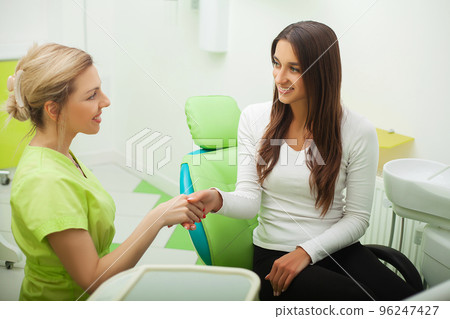 Young Dentist treating a female Patient in the dental studio Young Dentist treating a female Patient in the dental studio 96247427