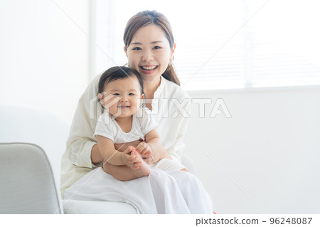 A mother holding a baby 96248087