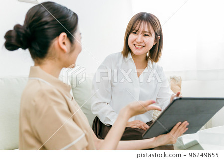 Japanese woman consulting with a counselor staff who offers counseling at a beauty salon 96249655