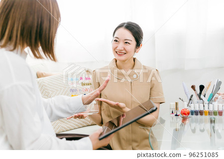 日本女性一邊在美甲沙龍看指甲尖一邊接受美甲師的諮詢 日本女性一邊在美甲沙龍看指甲尖一邊接受美甲師的諮詢 96251085