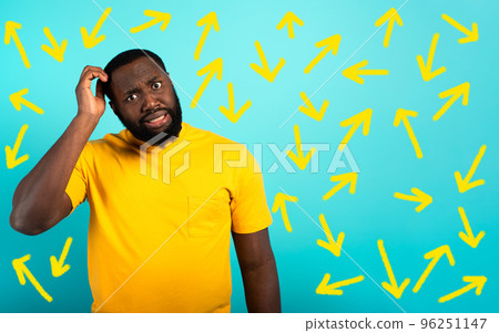 Confused Man have to choose the right arrow to follow. Concept of options, confusion, decision. Confused Man have to choose the right arrow to follow. Concept of options, confusion, decision. 96251147