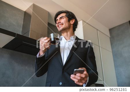Businessman works from remote at house with a smartphone due to coronavirus quarantine. Businessman works from remote at house with a smartphone due to coronavirus quarantine. 96251281