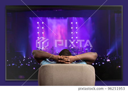 Viewer in front of a large TV relaxed on the armchair at home Viewer in front of a large TV relaxed on the armchair at home 96251953