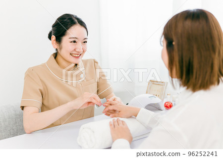 Manicurist sanding at nail salon and Japanese woman receiving treatment 96252241