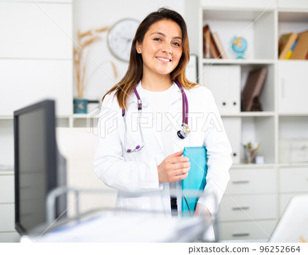 Woman doctor wear white medical uniform and stethoscope with blue folder of documents 96252664