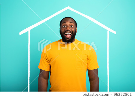 Man is amazed to have bought a house. Cyan background. 96252801