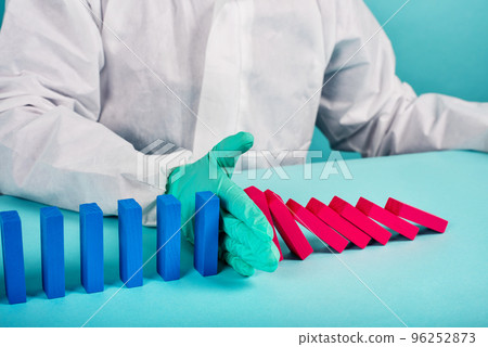 Concept of covid19 coronavirus pandemic with falling chain like a domino game. Contagion and infection progression stopped by a hand of a doctor. Cyan background Concept of covid19 coronavirus pandemic with falling chain like a domino game. Contagion and infection progression stopped by a hand of a doctor. Cyan background 96252873