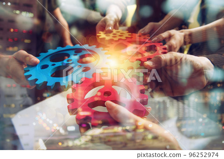 Business team connect pieces of gears. Teamwork, partnership and integration concept Business team connect pieces of gears. Teamwork, partnership and integration concept 96252974