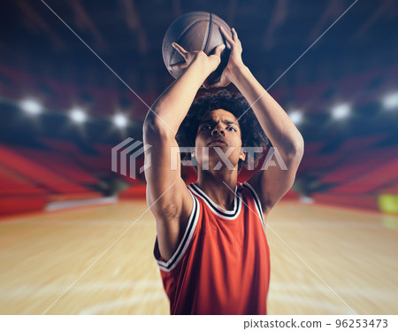 Young African American boy with basketball taking a free throw 96253473