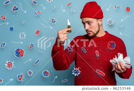 Boy caught a cold and uses spray to heal. Studio on Cyan background Boy caught a cold and uses spray to heal. Studio on Cyan background 96253546