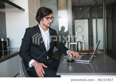 Businessman works from remote at house with a laptop due to coronavirus quarantine. Businessman works from remote at house with a laptop due to coronavirus quarantine. 96253987