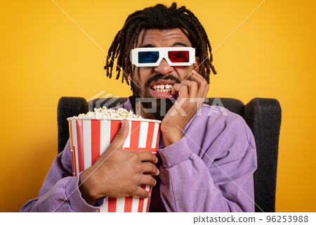 Boy has fun watching a film. Concept of entertainment and streaming tv. yellow background 96253988
