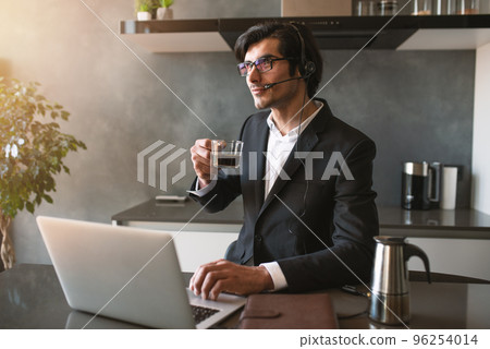 Businessman works from remote at house with a laptop due to coronavirus quarantine. Businessman works from remote at house with a laptop due to coronavirus quarantine. 96254014