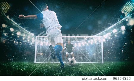 Soccer scene at night match with player in a white and blue uniform kicking the penalty kick Soccer scene at night match with player in a white and blue uniform kicking the penalty kick 96254533
