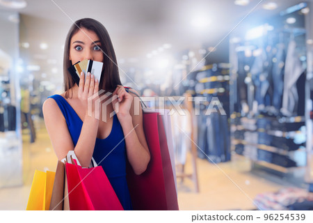 Happy woman at the shopping center with shopping bags and credit card Happy woman at the shopping center with shopping bags and credit card 96254539