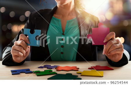 Businesswoman join two puzzle pieces. concept of teamwork and partnership. Businesswoman join two puzzle pieces. concept of teamwork and partnership. 96254544