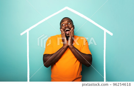 Man is amazed to have bought a house. Cyan background Man is amazed to have bought a house. Cyan background 96254618