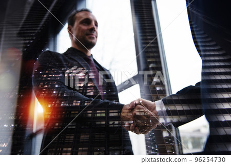Handshaking business person in office. concept of teamwork and partnership. 96254730