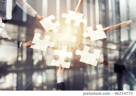 Teamwork of partners. Concept of integration and startup with puzzle pieces. Double exposure 96254773