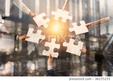 Teamwork of partners. Concept of integration and startup with puzzle pieces. Double exposure 96255255