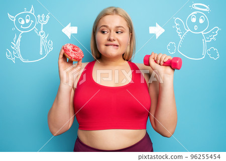 Fat girl thinks to eat donuts instead of does gym. Concept of indecision and doubt with angel and devil suggestion 96255454
