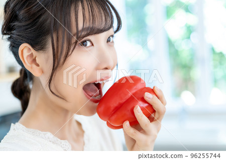 年輕女人在廚房裡咬辣椒粉 年輕女人在廚房裡咬辣椒粉 96255744