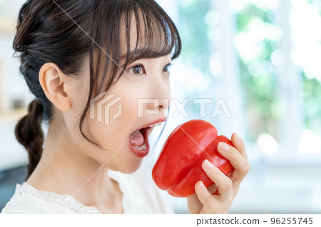 年輕女人在廚房裡咬辣椒粉 96255745